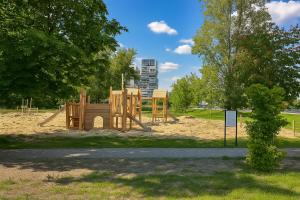 einen Park mit einem Holzspielplatz im Gras in der Unterkunft Apartament Szafirowy Paderewskiego 47a Dzielnica Parkowa Rzeszów in Rzeszów