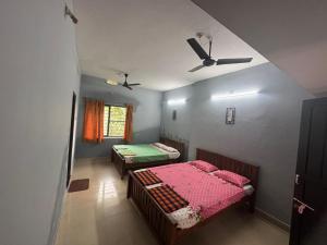 a room with two beds and a ceiling fan at ROB'S INN Groupstay 