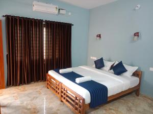 a bedroom with a large bed with blue walls at Casa Branca Retreat &Hub in Varkala