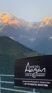 a sign for a hotel gate and restaurant in front of a mountain at Hotel aagan cafe and resturant in Astam