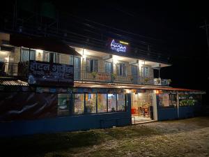 a sign on the side of a building at night at Hotel aagan cafe and resturant in Astam