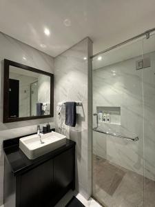SamporoにあるDesigner Residence Luxury Full Marble Branz bsdの洗面台とシャワー付きのバスルーム