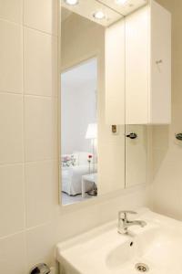 Un baño blanco con lavabo y espejo. en 4 friends HOSTEL, en Cracovia