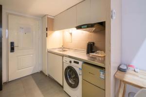 une petite cuisine avec un lave-linge et un lave-linge dans l'établissement Tianhe Residence, Shanghai, à Shanghai