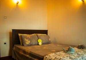 a bed with a stuffed animal sitting on top of it at Knight's Dale Knuckles Holiday Bungalow in Kandy