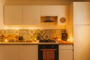 a kitchen with white cabinets and a stove top oven at Agréable 3,5 pièces situé au pied du château in Porrentruy +3 photos
