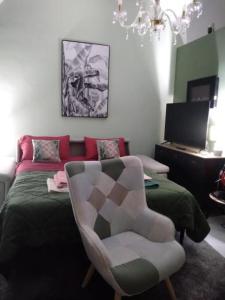 sala de estar con cama y silla en Armony House, en Trecastagni