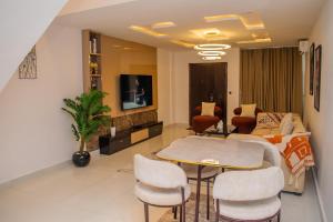 a living room with a couch and a table and chairs at Pwj Realty Apartments in Lekki
