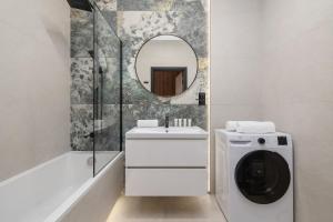 a white bathroom with a sink and a mirror at Elegant Studios in Katowice with Gym, Sauna & Cinema by Noclegi Renters in Katowice