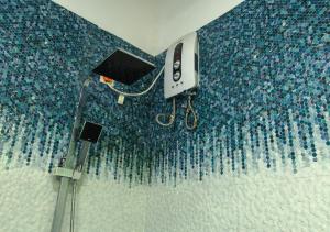 a bathroom with a blue tiled wall with a phone at Knight's Dale Knuckles Holiday Bungalow in Kandy