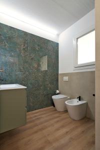 a bathroom with two sinks and a tub and a toilet at Il Papavero, raffinato, accogliente, lussuoso appartamento in Santo Stino di Livenza