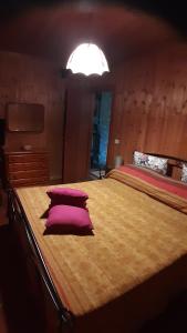 a bedroom with a large bed with purple pillows at La Baita Baretana 2 in Barete