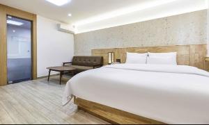 una camera da letto con un grande letto bianco e una sedia di Hotel Pacific a Suwon