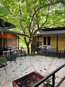 a patio with benches and a tree and a building at Green Garden Resort in Ban Nua