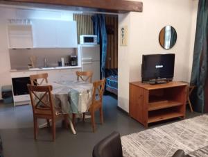 a kitchen and a dining room with a table and a television at Studio Miribel in Miribel +3 photos