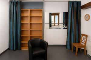a room with a black chair and a mirror at Studio Miribel in Miribel