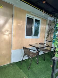 a patio with two chairs and a table in front of a house at Green Garden Resort in Ban Nua