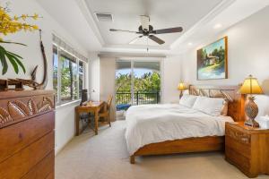 Un dormitorio con una cama y un escritorio y una ventana. en Fairways Mauna Lani 1406 condo, en Waikoloa