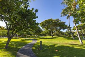 un camino a través de un parque con palmeras en Fairways Mauna Lani 1406 condo, en Waikoloa 42 fotos más