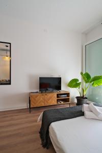 a bedroom with a flat screen tv and a bed at Il Papavero, raffinato, accogliente, lussuoso appartamento in Santo Stino di Livenza