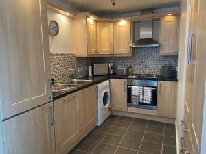 a kitchen with a washer and a sink and a dishwasher at Pennethorne Apartment in Clooney Park
