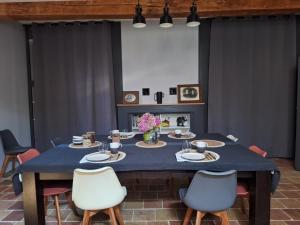 a blue table with chairs and plates and flowers on it at Le pigeonnier de Pauly in Mirabel