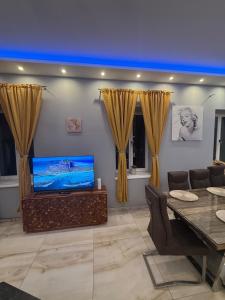 a living room with a tv and a dining table at Luxusvilla im Herzen von Baden in Baden