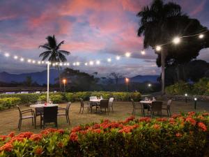 a dining area with tables and chairs at night at Novotel Nadi in Nadi