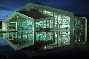 un grande edificio di vetro con le luci accese di notte di House 1 room Gamá COP30 a Belém