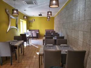 a dining room with tables and chairs and yellow walls at Hostal Restaurant Cal Duran in Esparraguera