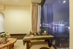 a room with a table and a window with a view at Baihong Riverview aparment-ChaoTianMen in Chongqing