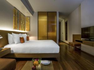 a hotel room with a bed and a television at Pullman Bangkok King Power in Bangkok
