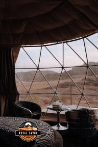 a tent with a table and chairs in front of a window at ROYAL SAVOY lUXURY CAMP in Wadi Rum