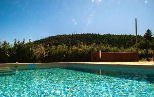 a large blue swimming pool with a hill in the background at Rocca Contrada in Arcevia