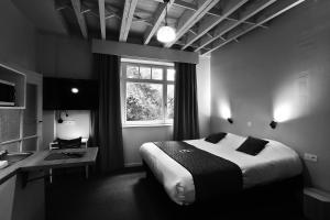 a bedroom with a large bed and a window at Aparthotel Acacia in Eeklo