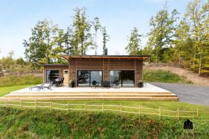 a tiny house on a hill with a porch at Holiday home with sauna and lake view in scenic Lonashult in Finnanäs