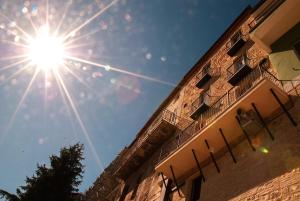 a sun in the sky next to a building at Rocca Contrada in Arcevia