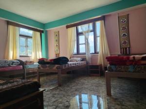 a room with beds and windows in a room at Mochilero Nomads in Pelling