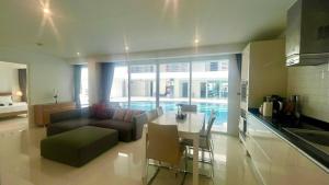 a kitchen and living room with a couch and a table at Sunset Plaza Condominium in Ban Karon