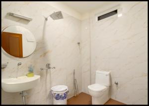 łazienka z toaletą, umywalką i lustrem w obiekcie HOTEL - NEW BEST - M ! MG - ! Varanasi - Free Wi - Fi & Fully Air Conditioned Hotel - Near Kashi Vishwanath Temple !! w mieście Rāmnagar