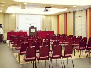 a conference room with red chairs and a podium at Hotel Mercure Siracusa in Siracusa +143 photos