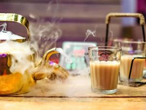 a tea kettle and a glass of coffee on a table at ibis Bengaluru City Centre - An Accor Brand in Bengaluru