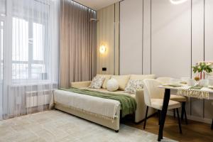 a bedroom with a bed and a table and a dining room at Oasis Халал апартаменты возле самой большой Мечети Центральной Азии in Astana