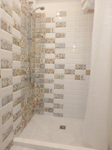 a bathroom with a shower with tiled walls at Holiday apartment Sombrero in Nea Peramos
