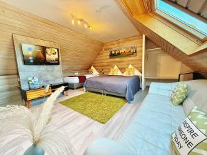 a bedroom with a bed and a couch in a room at Das Waldhaus - Winter Boardinghaus in Forbach