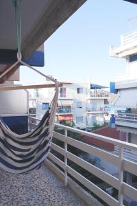 a hammock hanging on a balcony overlooking a city at Holiday apartment Sombrero in Nea Peramos