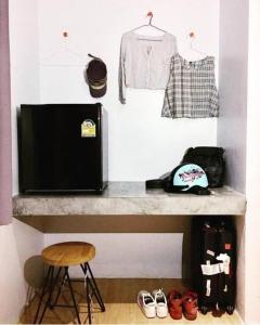 Una habitación con un estante con un televisor y ropa. en Us Hostel Samui, en Bophut 