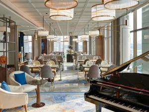 a lobby with a piano and tables and chairs at VIE Hotel Bangkok - MGallery Collection in Bangkok