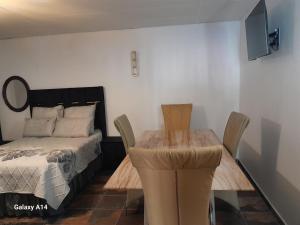 a bedroom with a bed and a table and chairs at VM Guesthouse Premium Suites in Estcourt