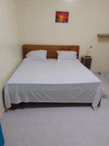 a large white bed in a white room with at Accueil 1 in Rufisque